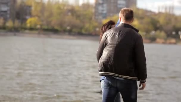 Liefhebbers van wandelen in het park, kus, in een romantische omgeving in de buurt van het meer — Stockvideo