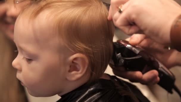 In einem brutalen Friseur wird ein kleines Kind von einem Clipper geschoren — Stockvideo