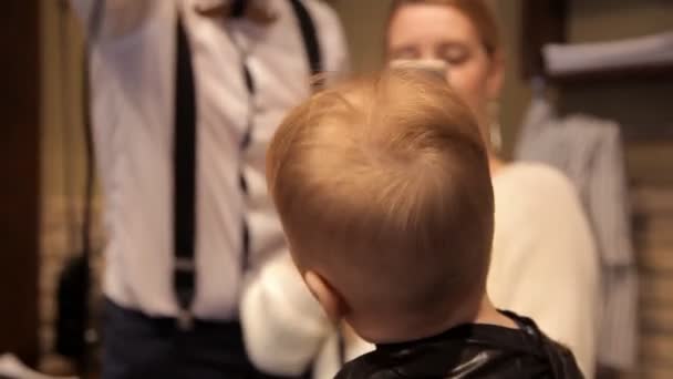 Een klein kind een föhn drogen na kapsel — Stockvideo