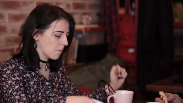 Milující pár jí rohlík a sendvič v kavárně, pití kávy — Stock video