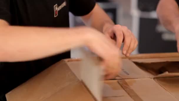 Workers unpack boxes in which there is professional lighting equipment, spotlights, light control panels, mirror balls, to illuminate the scene or the dance floor in the club — Stock Video