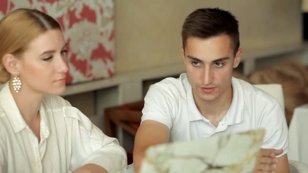 Der Hochzeitsorganisator zeigt den zukünftigen Bräutigam auf einem Laptop-Foto, um den Raum für die Hochzeit auszuwählen. — Stockvideo