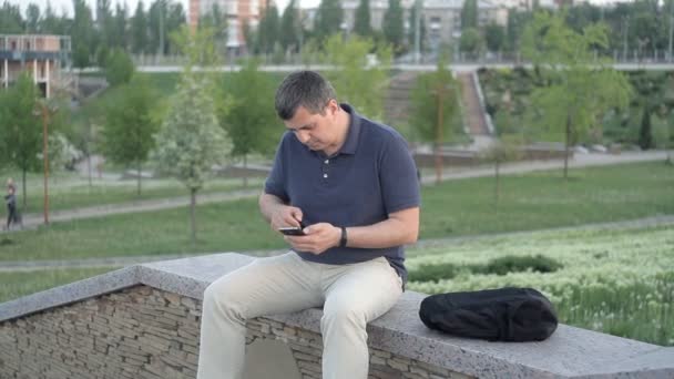 Yeşil bir arka plan üzerinde parkta oturan bir adam, bilinmeyen bir çantasını çaldı ve kaçtı — Stok video