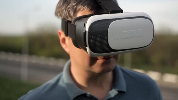 Людина використовує шолом віртуальної реальності. Пірнати в ігри або панорамне відео - фільм, який обертається навколо нього, і оглядається навколо, як у житті. Світ віртуальної реальності — стокове відео