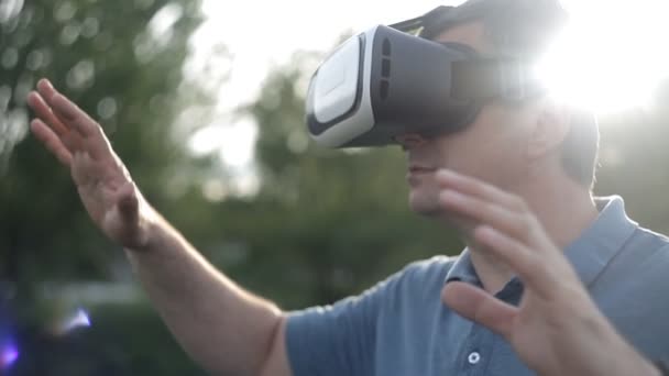 Людина використовує шолом віртуальної реальності. Пірнати в ігри або панорамне відео - фільм, який обертається навколо нього, і оглядається навколо, як у житті. Світ віртуальної реальності — стокове відео