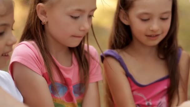 Les enfants s'amusent dans la nature et jouent. Les enfants sont versés dans les mains de sable coloré pour le jeu — Video