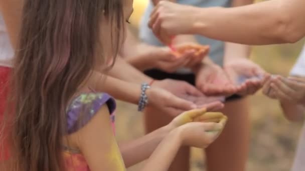 En un día soleado de verano, los niños pasan tiempo en el césped, a los niños se les da una arena colorida para el juego. Divertido.Leto. Festival de primavera — Vídeos de Stock