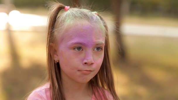 Un niño se divierte jugando en la naturaleza jugando con pinturas coloridas y arena. El niño cerró los ojos y lo roció con arena colorida. Divertido. Juegos en la naturaleza — Vídeos de Stock