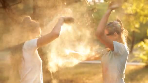 Barnen har roligt i parken rekreation, kastar färgat pulver holi. Childrens resten i soligt väder — Stockvideo