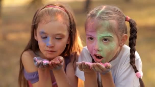 Two girls blow off colored powder from their hands. Holi Festival — Stock Video