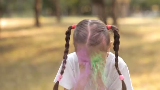 Schattig klein kind plezier op natuur spelen met kleurrijke verf en zand. Hij giet gekleurd zand op zijn gezicht. Childrens vreugde. Kinder spellen — Stockvideo