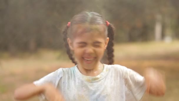 Con bambini tolgono lavando la polvere colorata holi con acqua. Riposo in un parco ricreativo. Sorrisi, divertimento, gioia dei bambini — Video Stock
