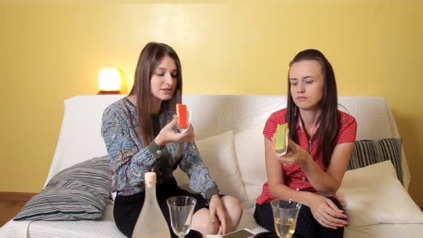 Schöne junge Mädchen an einem regnerischen Tag auf der Couch zu Hause sitzen und leckere Kuchen mit Orange und Pistazien, Kiwi essen, Wein trinken. Freundschaft, Kommunikation, Essen, Zuhause, Regen — Stockvideo