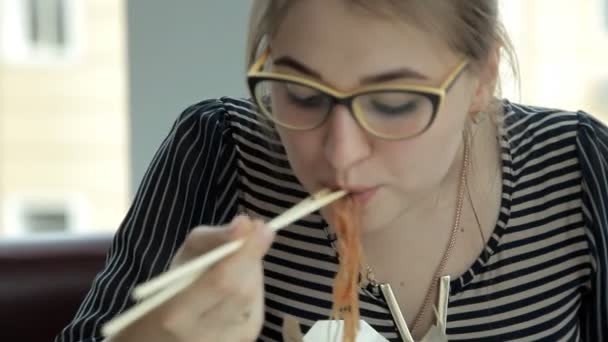 Młody biznes dziewczynka jedzenie chiński makaron na obiad. Biznesowe, lunch, chińskie jedzenie — Wideo stockowe