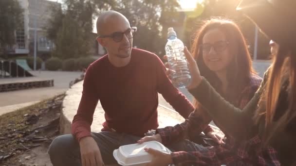 Twee jonge meisjes en hun vriend een kale vriend tijd doorbrengen in het park, communiceren en lachen. Weer, vriendschap, warmte — Stockvideo