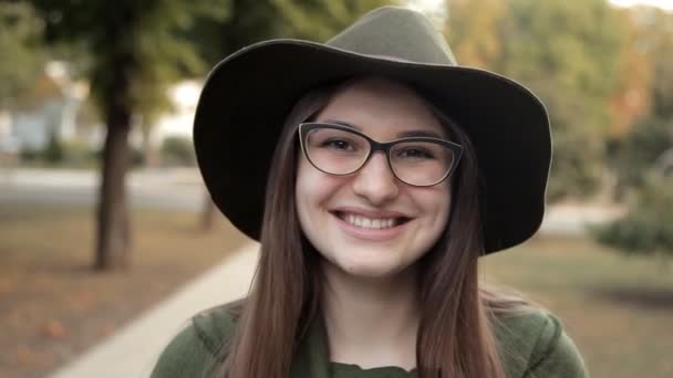 Hermosa joven en el parque de otoño, sus emociones y sonrisa — Vídeos de Stock