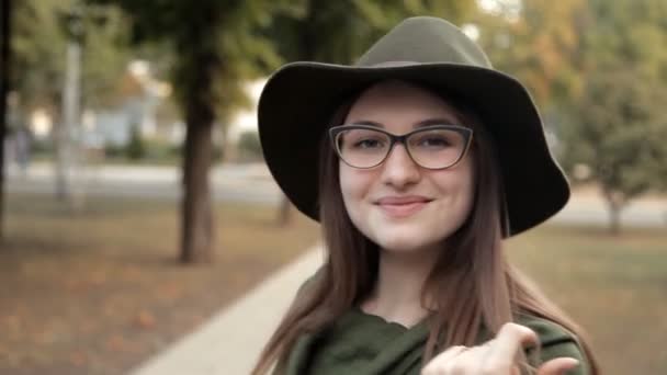 Záhadná mladá dívka chodí v podzimním parku, její úsměv a emoce. Park, podzim, dívka — Stock video