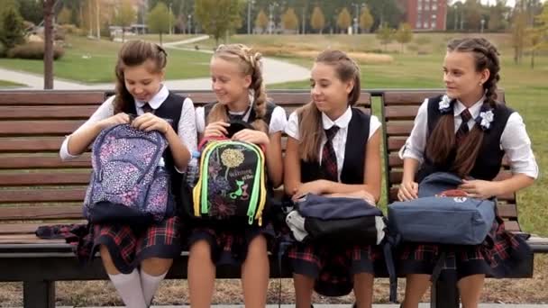 Kinderen in school uniform in het park tijdens de lunch eten broodjes. School, voedsel, rest — Stockvideo