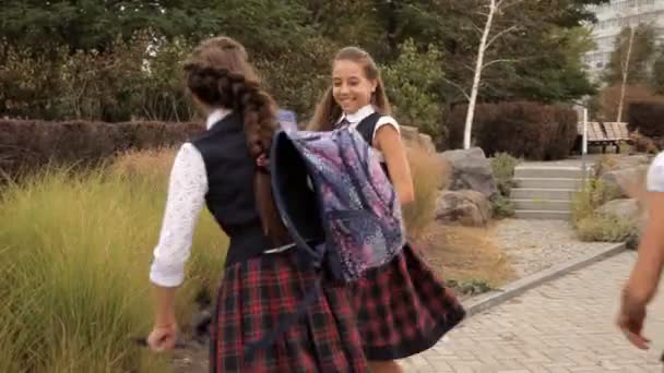 Crianças de uniforme escolar depois da escola em um passeio no parque. Natureza, diversão, riso — Vídeo de Stock