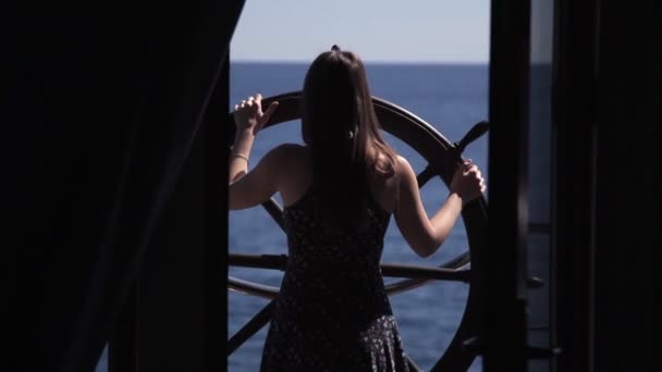 Una joven está en el volante en la terraza de la habitación del hotel con vistas al mar — Vídeos de Stock