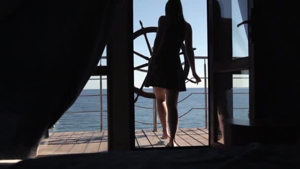 A young girl leaves the room on a terrace overlooking the sea — Stock Video