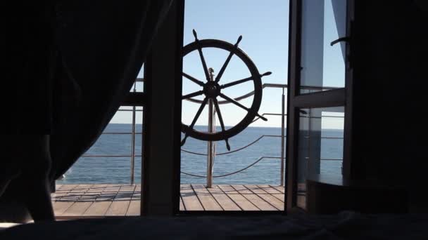 En la terraza con vistas al mar está el volante. Vista desde la habitación a la terraza — Vídeos de Stock