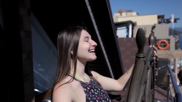 Joyful girl rotates the ships steering wheel — Stock Video
