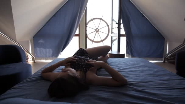 Young girl lying on the bed overlooking the terrace — Stock Video