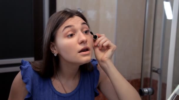 Egy fiatal lány készül egy romantikus vacsorára, és csinál smink, felhívja a szem szempillaspirál — Stock videók