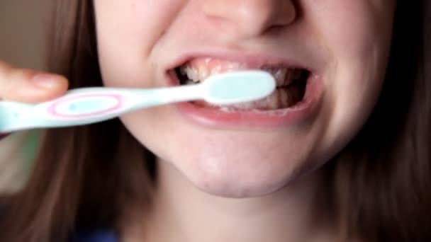 Молодая девушка позирует перед камерой, чистит зубы. Здоровые зубы — стоковое видео