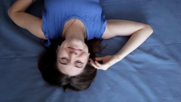 Menina jovem dormindo na cama azul e, em seguida, feliz acorda — Vídeo de Stock