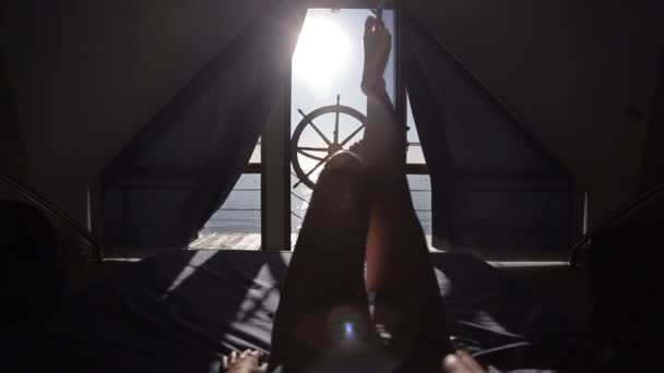 Молодая девушка проснулась рано утром в постели с видом на море и террасу — стоковое видео