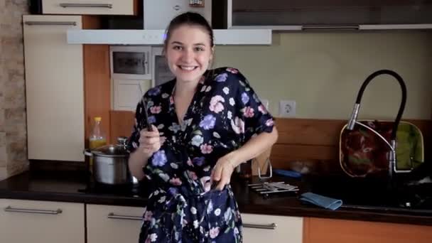 Młoda dziewczyna czyści się w kuchni, żarty i taniec. Dobry nastrój rano — Wideo stockowe