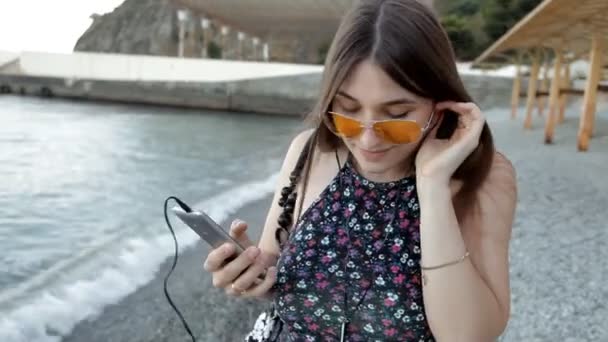 Chica caminando en la playa escuchando música y bailando — Vídeos de Stock