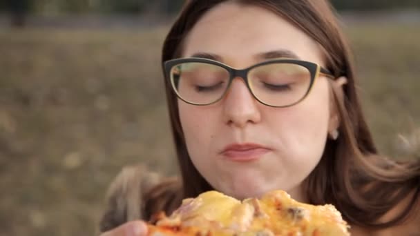 Fiatal lány a kamera, a csirke és a gomba finom pizzát eszik — Stock videók