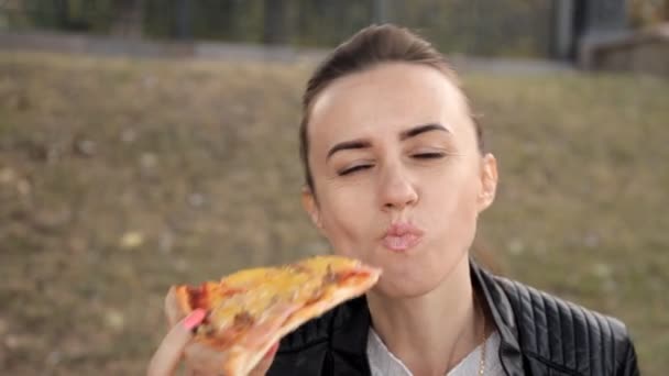 Jovem na frente da câmera comendo pizza deliciosa com frango e cogumelos — Vídeo de Stock