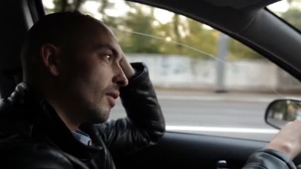 Hombre calvo conduciendo un coche en la ciudad — Vídeos de Stock