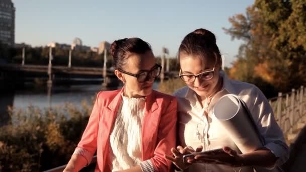 Dos niñas arquitectos se paran junto al río y discuten el proyecto de construcción. Negocios, construcción — Vídeo de stock