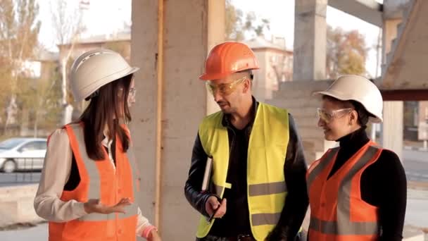 Builder ve kadın mimar İnşaat planı tartışmak ve kamera için poz. Yeni bir proje inşaatı — Stok video