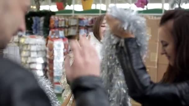 Amigos bailan en el supermercado y compran decoraciones navideñas — Vídeo de stock