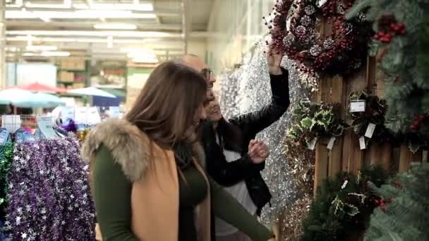 Two girls and a man choose Christmas toys — Stock Video