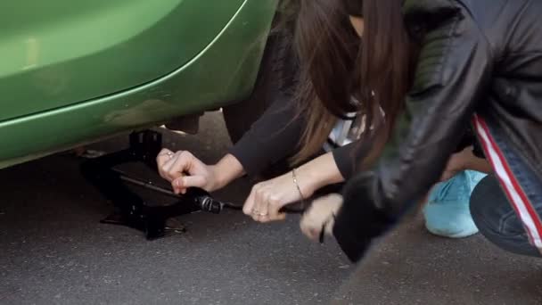 Mädchen am Straßenrand lernen, den Reifen an seinem Auto zu wechseln — Stockvideo