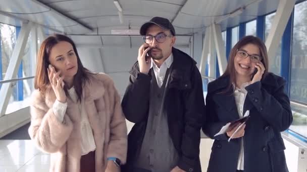 Τρεις άνθρωποι που μιλάτε στο τηλέφωνο στο αεροδρόμιο — Αρχείο Βίντεο