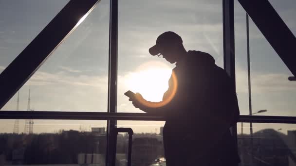 Hombre en el fondo del atardecer en el aeropuerto hablando por teléfono — Vídeos de Stock