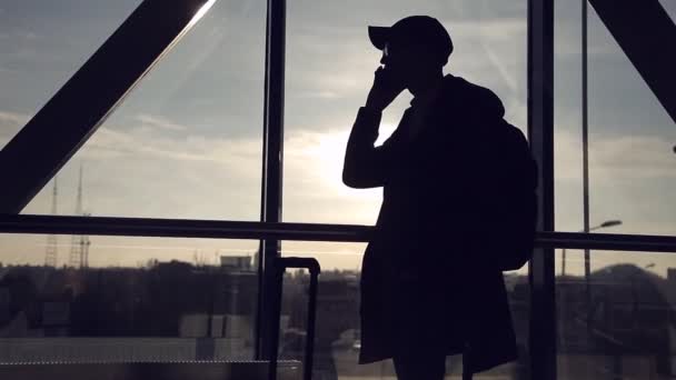 Hombre en el fondo del atardecer en el aeropuerto hablando por teléfono — Vídeo de stock