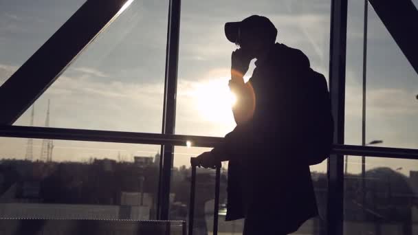 Homme sur fond de coucher de soleil à l'aéroport parlant au téléphone — Video