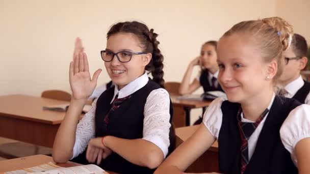 Elever barn sitter vid sina skrivbord, höjer några av dem händerna — Stockvideo