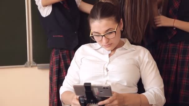 학교 유니폼 학생 교사는 휴대 전화에서의 자에 앉아 가까이 서 있다. 학교 교육의 개념 — 비디오
