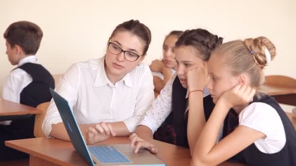 Profesor discutiendo un programa de computadora con un grupo de alumnos — Vídeo de stock