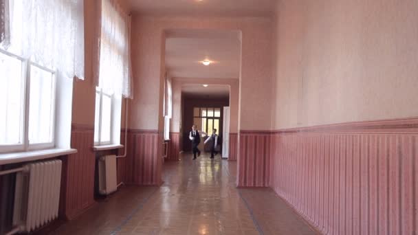 Een groep kinderen loopt langs de corridor in de school — Stockvideo